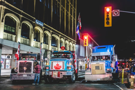 Ottawa, Ontario, Canada - February 11, 2022. Blocked Wellington Street with Trucks and Cars and many Protesters at Night.のeditorial素材