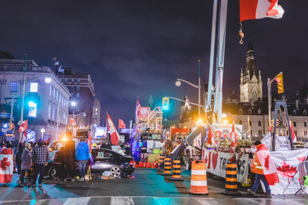 Ottawa, Ontario, Canada - February 11, 2022. Blocked Wellington Street with Trucks and Cars and many Protesters at Night.のeditorial素材
