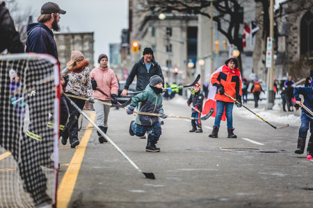 Ottawa, Ontario, Canada - February 11, 2022. People and kids playing hockey in front of parliament during Freedom Convoy Protest in Ottawa.のeditorial素材