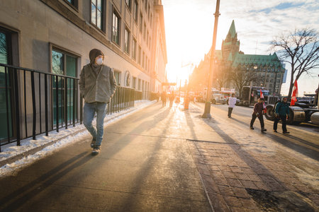 Ottawa, Ontario, Canada - February 13, 2022. Person Walking Alone with Face Mask Outside during Freedom Convoy Protest in Ottawa.のeditorial素材