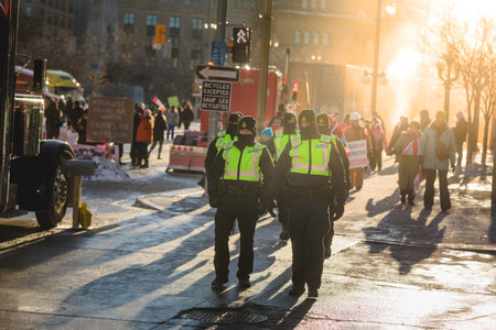Ottawa, Ontario, Canada - February 13, 2022. Few Police Officers au Sunset during Freedom Convoy Protest in Ottawa.のeditorial素材