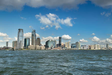 Skyline cityscape view from Battery Park of the office buildings and skyscrapers over the Hudson River waterfront of New Jersey USAの写真素材