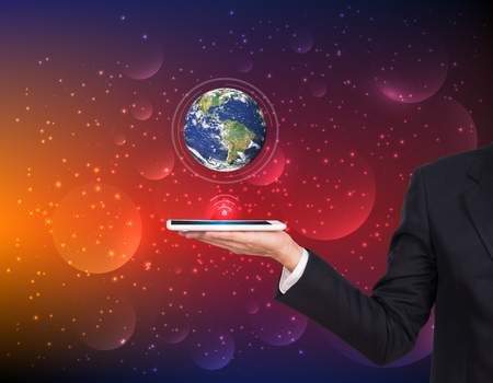 Businessman hands holding tablet with Earth planet on abstract background.の写真素材