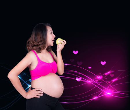 happy pregnant woman holding green apple overの写真素材