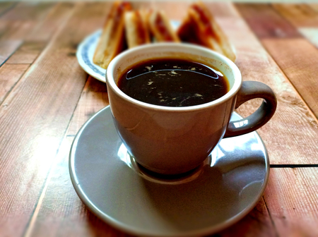 Black coffee with sandwich on wooden tableの写真素材