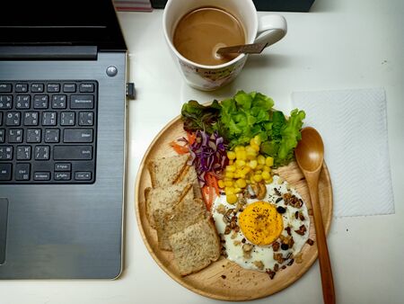 Breakfast time: Fried egg, whole wheat bread, vegetable salad with hot coffee.