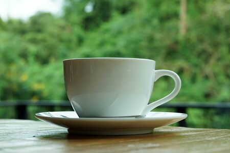 A cup of hot coffee on wooden table.の写真素材