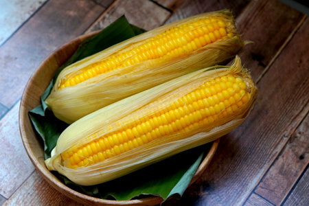 Boiled sweet corn in a bowl on wooden background.