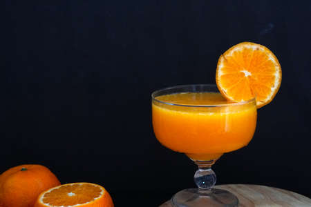 Fresh orange fruit makes orange juice in a glass.