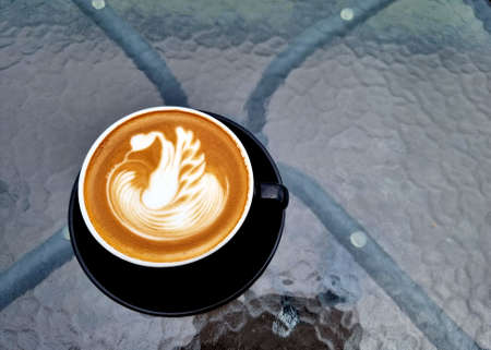 Sideway shop coffee, a cup of hot latte art coffee on the table.の写真素材