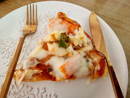 Delicious seafood cocktail pizza separated on the plate with knife and fork.の写真素材