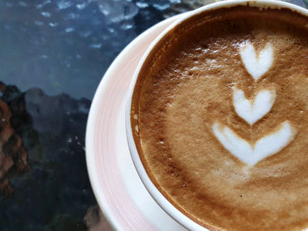 Close-up a cup of hot latte art coffee on the table.