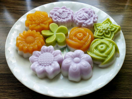 Thai traditional dessert coconut milk jelly flowers on wooden background.
