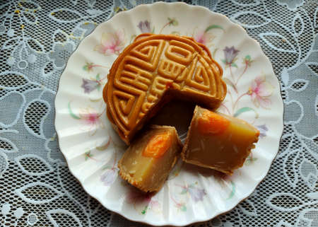 Durian moon cake with egg yolk on a plate is a Chinese bakery product traditionally eaten during the...