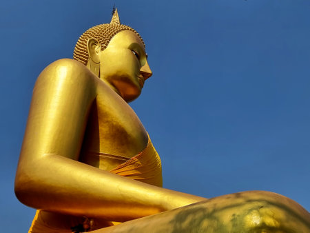 Pra Puttha Ariya Thammo Buddha on blue sky background: The Buddha statue on the hillside, a large and beautiful Marn Vichai style which is Sukhothai art at Wat Kao Plong temple, Chai Nat, Thailand.の写真素材