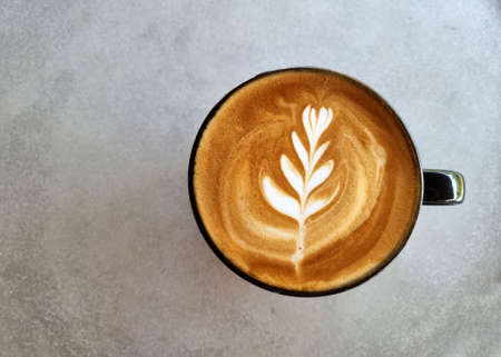 Sideway shop coffee, a cup of hot latte art coffee on the table.の写真素材