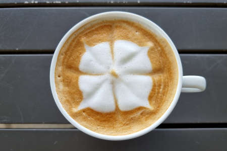 Sideway shop coffee, a cup of hot latte art coffee on wooden background.