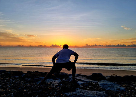 The man exercise on the beach while sunrise in the early morningの写真素材