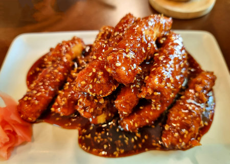 The Spicy fried Chicken Korean sauce with pickled ginger on a white plate.の写真素材