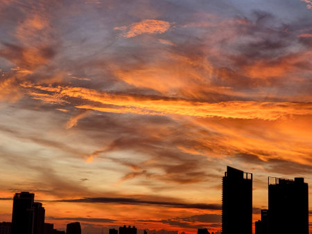 Sunset clouds in the sky background over the cityの写真素材