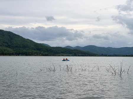 The perspective of two people paddling a kayak on the reservoir, relaxing on a holidayの写真素材