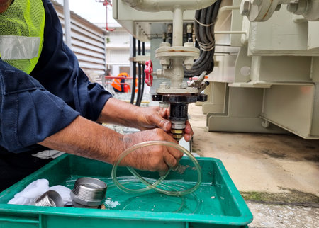 On-Site Transformer oil sampling in the factory for main tank and OLTC of 115kV/22kV power transformer.の写真素材