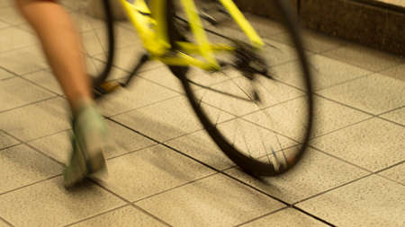 Blurry legs and bicycle in train stationの写真素材