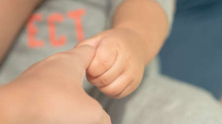 Baby grapping adult fingerの写真素材