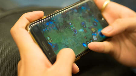Hands of a person playing game on a smartphone