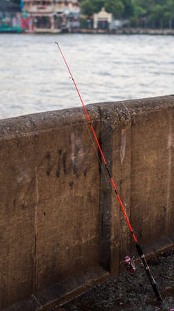 Fishing pole resting on a wallの写真素材
