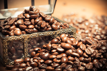 Coffee beans in coffer on teak wooden backgroundの写真素材