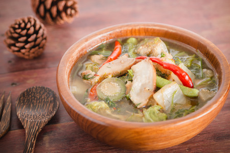 Northern Thai Spicy Soup with Pork "Kaeng Oom" on wooden table.の写真素材