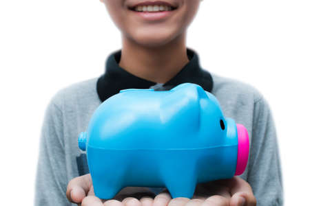 The boy holding a piggy bank with smiling faceの写真素材