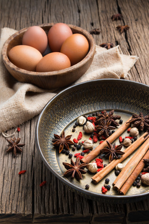 Various Spices and herbs with eggs on wood backgroundの写真素材