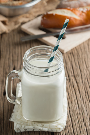 Fresh bread with milk on wooden groundの写真素材