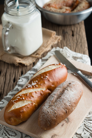Fresh bread with milk on wooden groundの写真素材