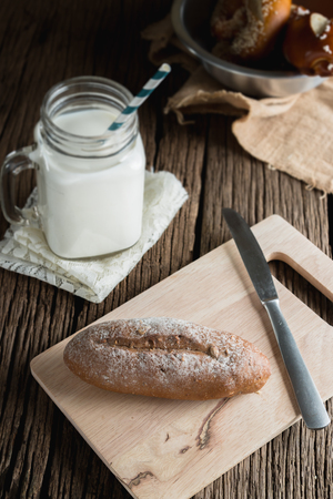 Fresh bread with milk on wooden groundの写真素材