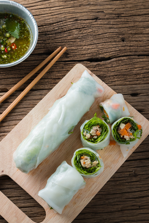 Fresh Spring Rolls with vegetables and pork on old wooden tableの写真素材