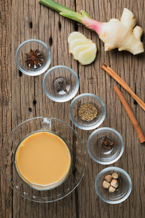 Masala chai with spices. Cinnamon stick, thai cardamom, ginger, clove, star anise, black peppercorns, fennel seeds, black teaの写真素材
