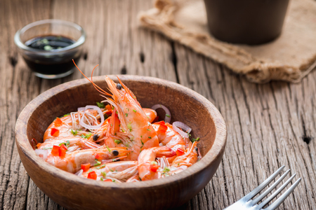 steamed shrimps in a wooden bowl on wood backgroundの写真素材