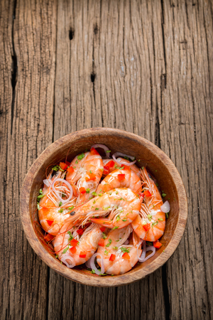 steamed shrimps in a wooden bowl on wood backgroundの写真素材