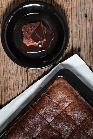 Cake chocolate brownies with dark chocolate dressing on wooden tableの写真素材