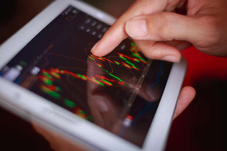 macro close up a man checking stock market on tablet, smartphoneの写真素材
