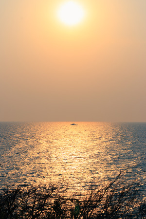 sunset with beautiful gold sky. Sunset reflection in sea water of island. Koh Sri Chang. Chonburi, Thailandの写真素材