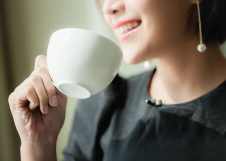 Beautiful woman drinking coffee happily.の写真素材