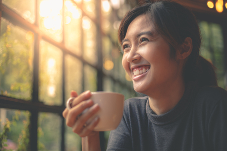 Beautiful woman drinking coffee happily.の写真素材