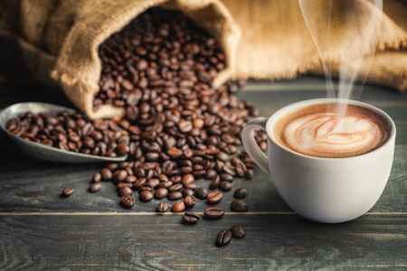 Coffee cup and coffee beans with bag, scoop and smoke - classic concept.の写真素材