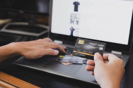 A man online shopping at home using credit card and laptop for online shopping, technology and...