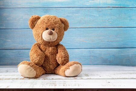 Cute teddy bear with copy space on blue color wood background.の写真素材