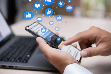 Man person hands holding smartphone for social interaction on social media with notification icons...